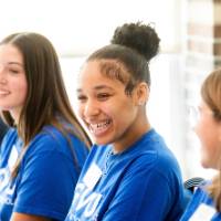 Three Thompson Scholar students sitting at table and smiling